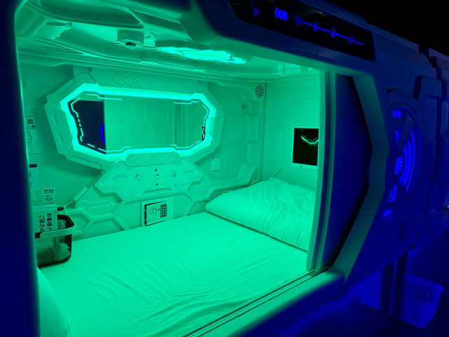 Two tiers of moulded sleeping berths along a lit corridor