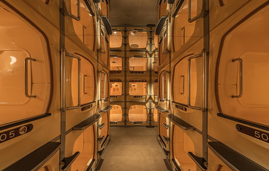 Two tiers of moulded sleeping berths along a corridor with fabric screens