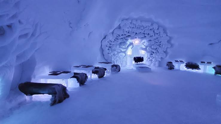 Corridor between joined ice domes with carved openings along one wall